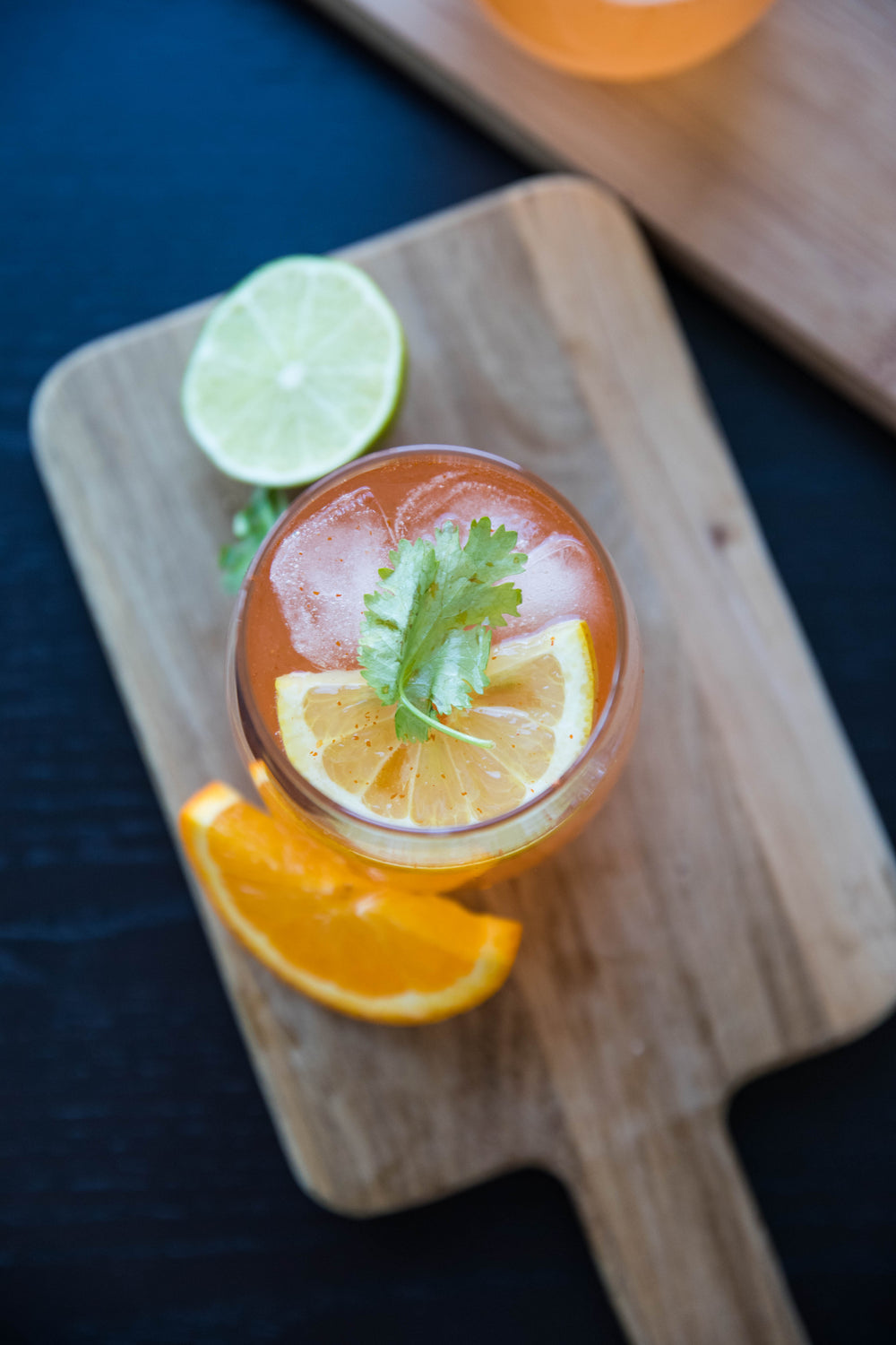 flatlay-of-orange-beverage-with-lime-and-orange-garnish
